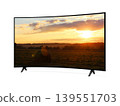 Curved screen tv from angled view with rural landscape with straw roll and sunset sky on screen 139551703