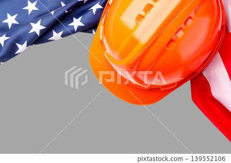 Hard hat rests near American flag showing Labor Day spirit 139552106
