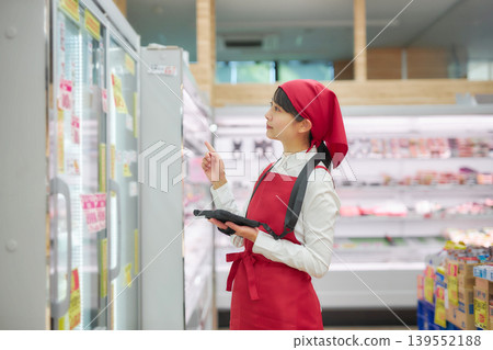 A young woman manages products using a tablet. A young woman manages products using a tablet. 139552188