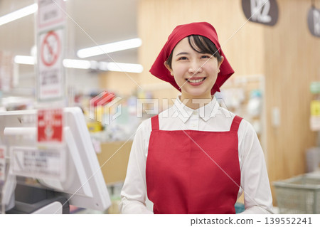 A young woman working at the checkout counter of a supermarket A young woman working at the checkout counter of a supermarket 139552241