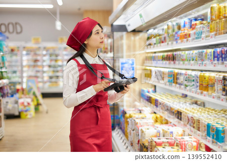 A young woman manages products using a tablet. 139552410