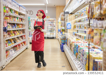 A young woman manages products using a tablet. 139552411