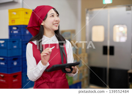 一位年輕女子在後屋使用平板電腦管理庫存。 139552484
