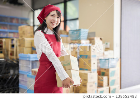 A young woman manages inventory using a tablet in the back room. 139552488