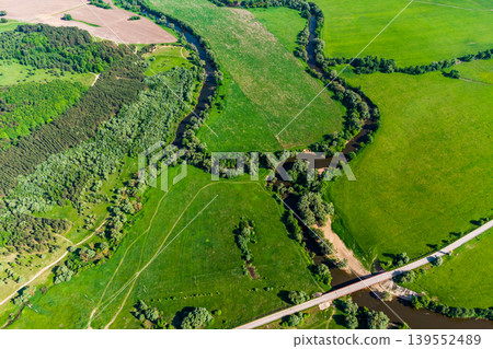 View from a high altitude of a landscape with a river and an oxbow surrounded by green fields View from a high altitude of a landscape with a river and an oxbow surrounded by green fields 139552489