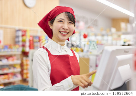 A young woman working at the checkout counter of a supermarket A young woman working at the checkout counter of a supermarket 139552604