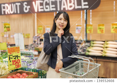 A young woman shopping at a supermarket on her way home from work. 139552608