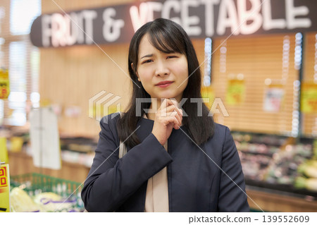 一位年輕女子下班回家途中在超市購物。 一位年輕女子下班回家途中在超市購物。 139552609