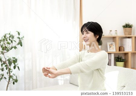 一位女士伸懶腰,讓自己放鬆。 一位女士伸懶腰,讓自己放鬆。 139553153