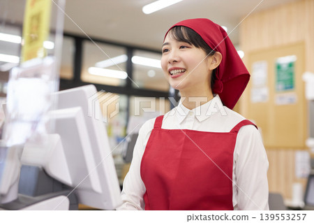 A young woman working at the checkout counter of a supermarket A young woman working at the checkout counter of a supermarket 139553257