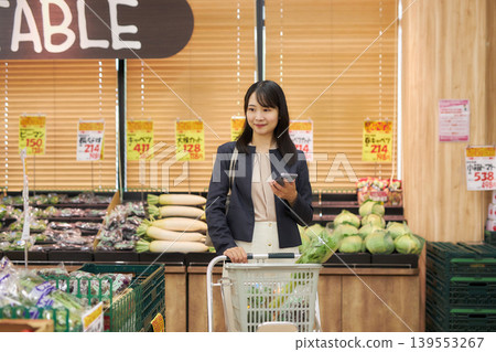 A young woman shopping at a supermarket on her way home from work. 139553267