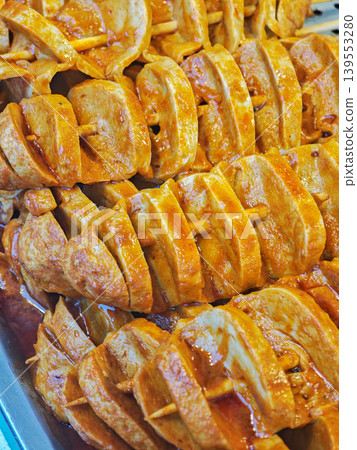 Grilled chicken skewers arranged neatly on a tray, showcasing marinated pieces of meat with a rich golden-brown color and wooden sticks for easy serving Grilled chicken skewers arranged neatly on a tray, showcasing marinated pieces of meat with a rich golden-brown color and wooden sticks for easy serving 139553280