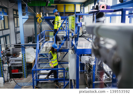 Industrial workers supervising automated manufacturing systems. Industrial workers supervising automated manufacturing systems. 139553592
