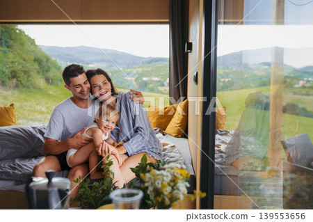 Young woman with husband and baby indoors, weekend away in small cotage n countryside. Young woman with husband and baby indoors, weekend away in small cotage n countryside. 139553656