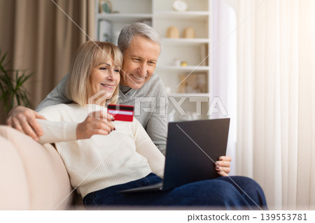 Senior couple shopping online at home with laptop and credit card Senior couple shopping online at home with laptop and credit card 139553781