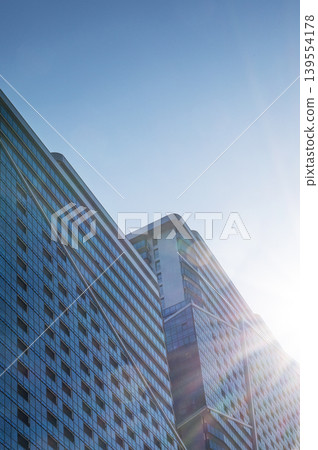 Modern high-rise residential buildings with glass facades against a clear blue sky. 139554178