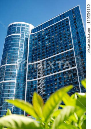 Modern high-rise residential buildings with glass facades against a clear blue sky. 139554180