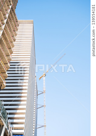 High-rise building under construction with tower crane, urban development and real estate concept 139554181