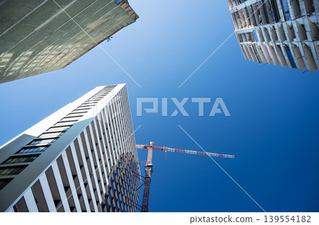 High-rise building under construction with tower crane, urban development and real estate concept 139554182