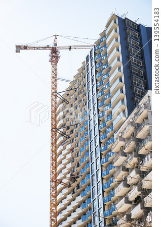 High-rise building under construction with tower crane, urban development and real estate concept High-rise building under construction with tower crane, urban development and real estate concept 139554183
