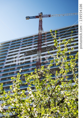 High-rise building under construction with tower crane, urban development and real estate concept 139554186