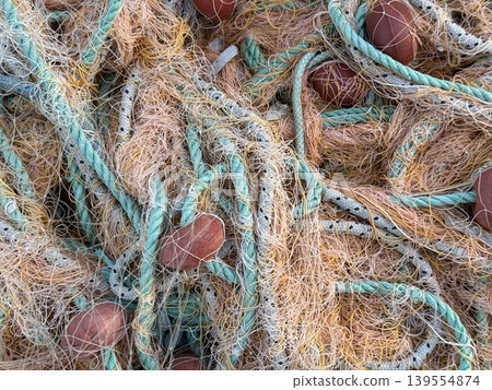 Fishing nets in closeup displaying ropes and floats, ideal for a nautical background 139554874