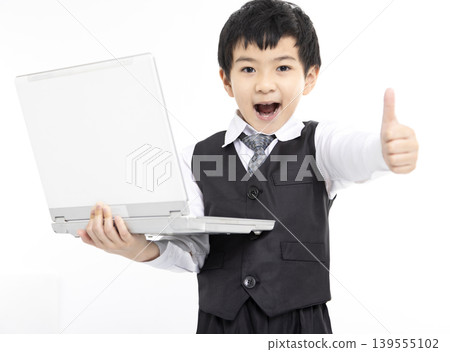 Happy boy gives thumbs up while using laptop Happy boy gives thumbs up while using laptop 139555102
