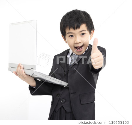 Happy  boy  gives thumbs up while using laptop 139555103