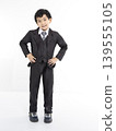 Happy boy wearing a suit standing over white background 139555105