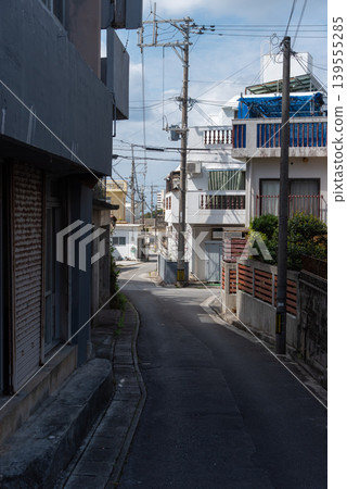 A back alley road with utility poles and power lines A back alley road with utility poles and power lines 139555285
