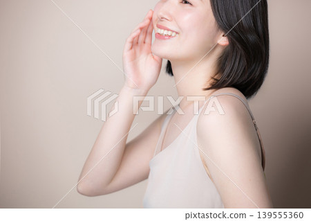 A close-up image of a smiling woman with translucent, beautiful skin against a beige background, showcasing skincare and beauty. A close-up image of a smiling woman with translucent, beautiful skin against a beige background, showcasing skincare and beauty. 139555360