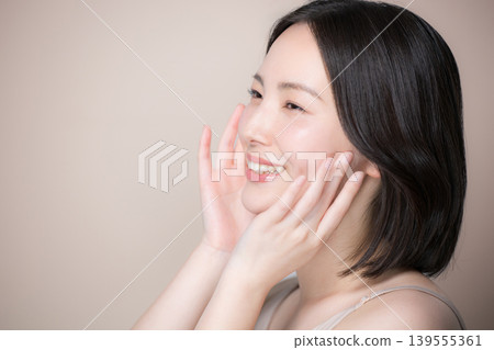 A close-up image of a smiling woman with translucent, beautiful skin against a beige background, showcasing skincare and beauty in profile. A close-up image of a smiling woman with translucent, beautiful skin against a beige background, showcasing skincare and beauty in profile. 139555361