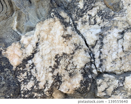 a close up image of textured rock surface, likely a section of granite or a similar igneous or metamorphic formation. a close up image of textured rock surface, likely a section of granite or a similar igneous or metamorphic formation. 139555640