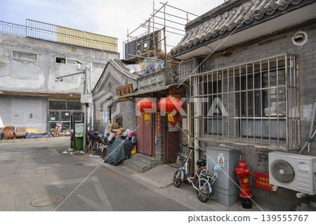 Narrow street with old houses and motorbikes in the Hutong district in Beijing Narrow street with old houses and motorbikes in the Hutong district in Beijing 139555767