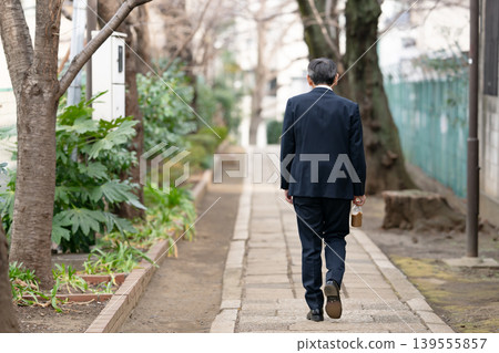 A businessman walking, seen from behind. A businessman walking, seen from behind. 139555857