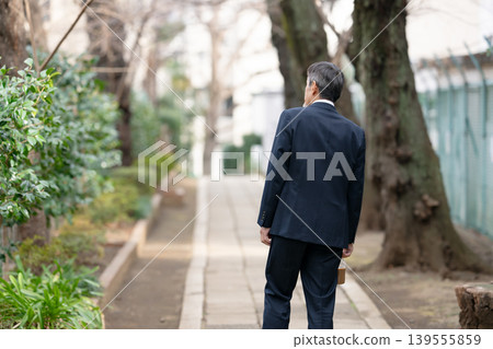 從背後拍攝的一位正在行走的商人。 139555859