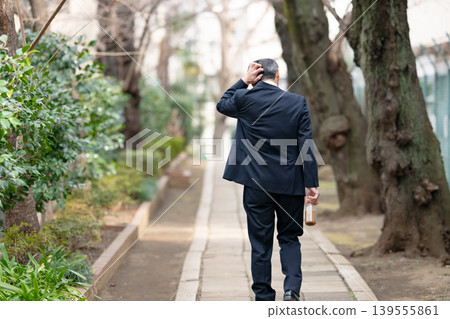 從背後拍攝的一位正在行走的商人。 139555861