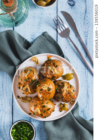 Roasted baby potatoes with green onions and olives on a plate on the table top and vertical view Roasted baby potatoes with green onions and olives on a plate on the table top and vertical view 139556019