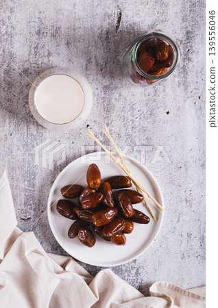 Healthy fresh dates in a bowl and milk in a glass on the table top and vertical view Healthy fresh dates in a bowl and milk in a glass on the table top and vertical view 139556046