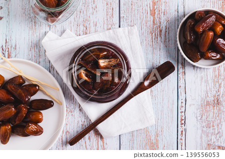 Sweet date marmalade in a jar and fruit in a bowl on a table top view Sweet date marmalade in a jar and fruit in a bowl on a table top view 139556053