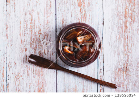 Close up of sweet date marmalade in a jar and spoon on a table top view Close up of sweet date marmalade in a jar and spoon on a table top view 139556054