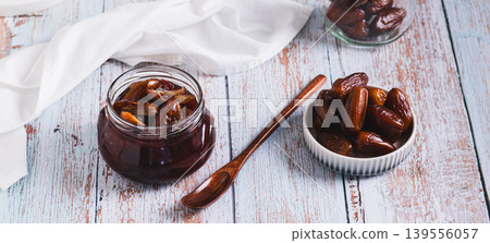 Sweet date marmalade in a jar and fruit in a bowl on a table web banner Sweet date marmalade in a jar and fruit in a bowl on a table web banner 139556057