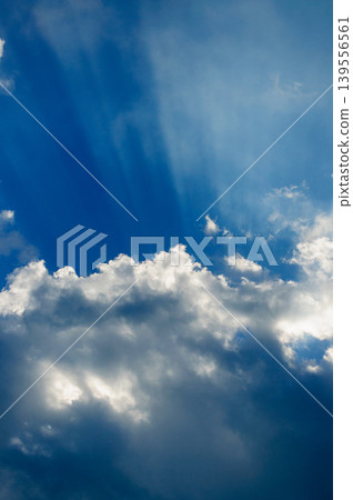 Rays of light (Jacob's Ladder) shining through the blue sky and shimmering clouds. Rays of light (Jacob's Ladder) shining through the blue sky and shimmering clouds. 139556561