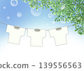 A scene of T-shirts drying in the blue sky and lush green leaves. 139556563