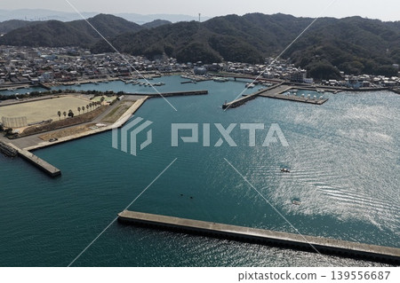 An aerial photograph showing the port of Kada in Wakayama Prefecture and the surrounding fishing village from a diagonal vantage point. An aerial photograph showing the port of Kada in Wakayama Prefecture and the surrounding fishing village from a diagonal vantage point. 139556687
