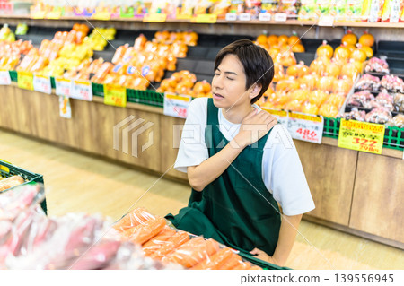 Shop employee with shoulder pain Shop employee with shoulder pain 139556945