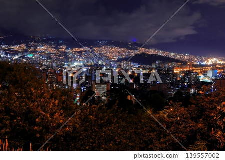 Night view of Medellín, Colombia: A carpet of lights spread across the mountain slopes and the city's nightscape. Night view of Medellín, Colombia: A carpet of lights spread across the mountain slopes and the city's nightscape. 139557002