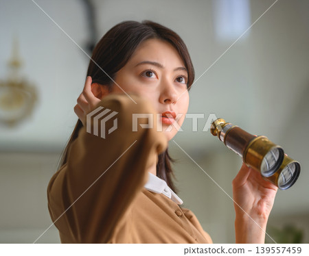一位女子手持望遠鏡沉思。 139557459