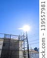 Exterior wall renovation site under a blue sky and sun: A detached house with ample open space. 139557981