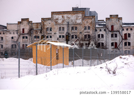Large abandoned factory facade in winter landscape 139558017